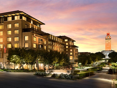Hotel-Attend Button The AT&T Hotel & Conference Center with the University of Texas tower in the background during sunset